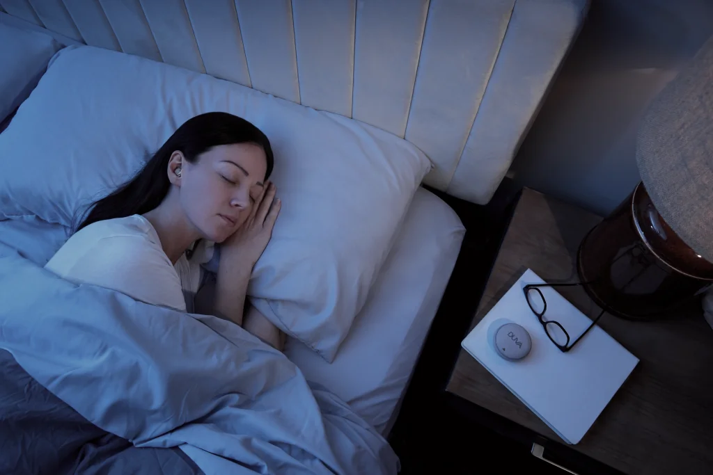 A woman resting on her side with DUVA sleep earbuds